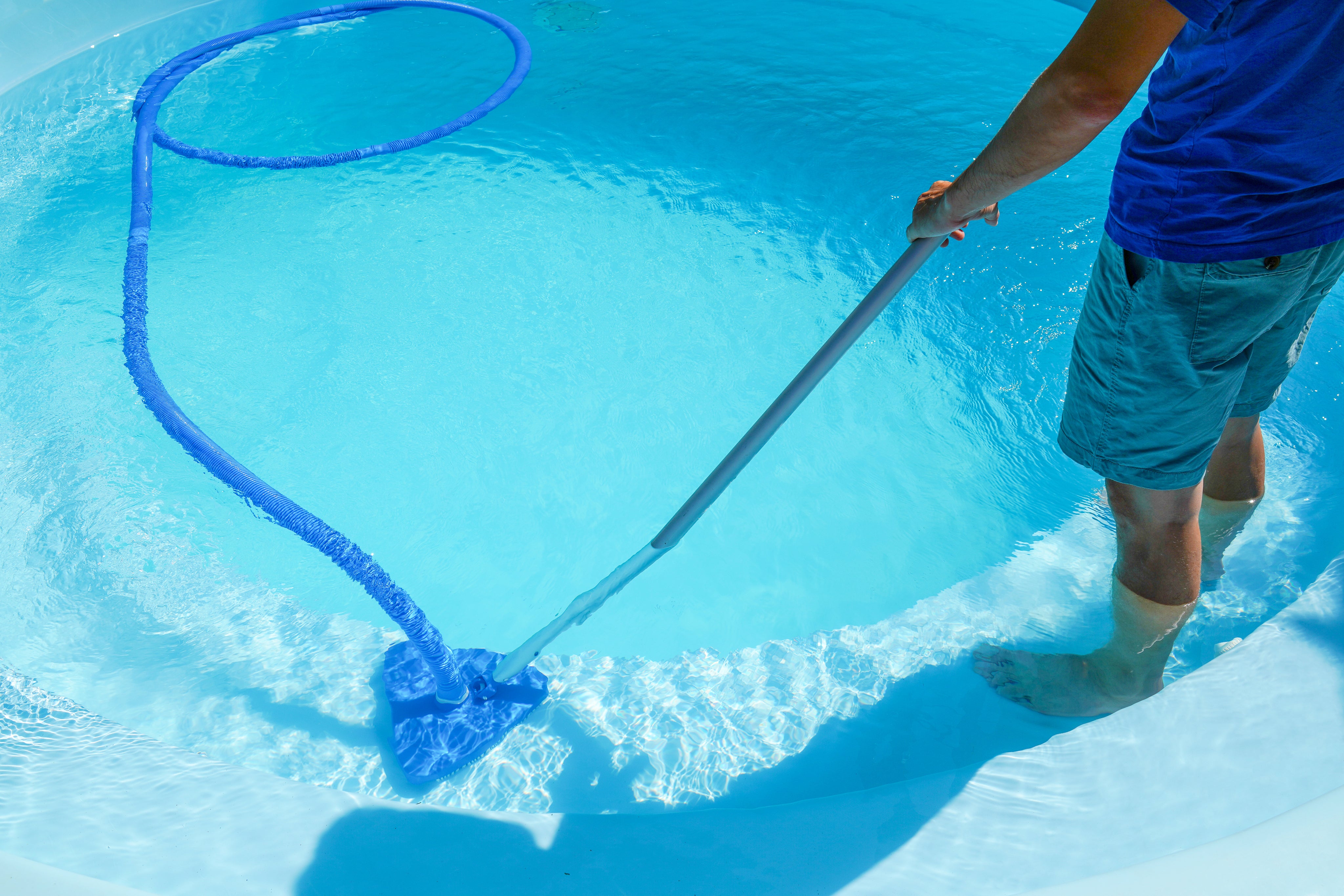 Pool service professional cleaning a pool